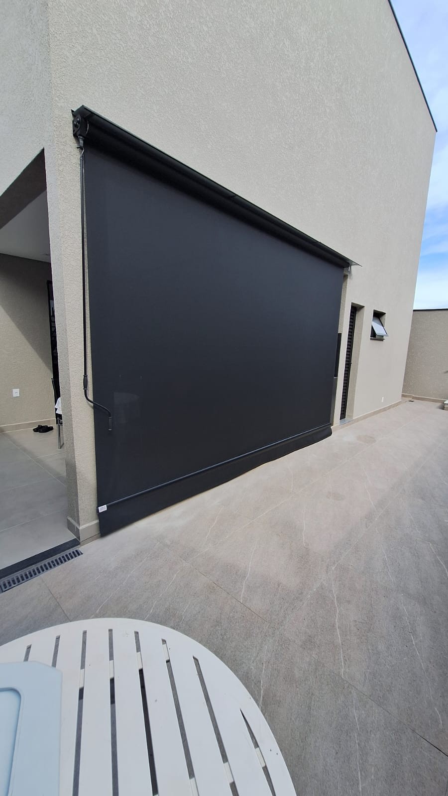 Toldo articulado preto em fachada residencial